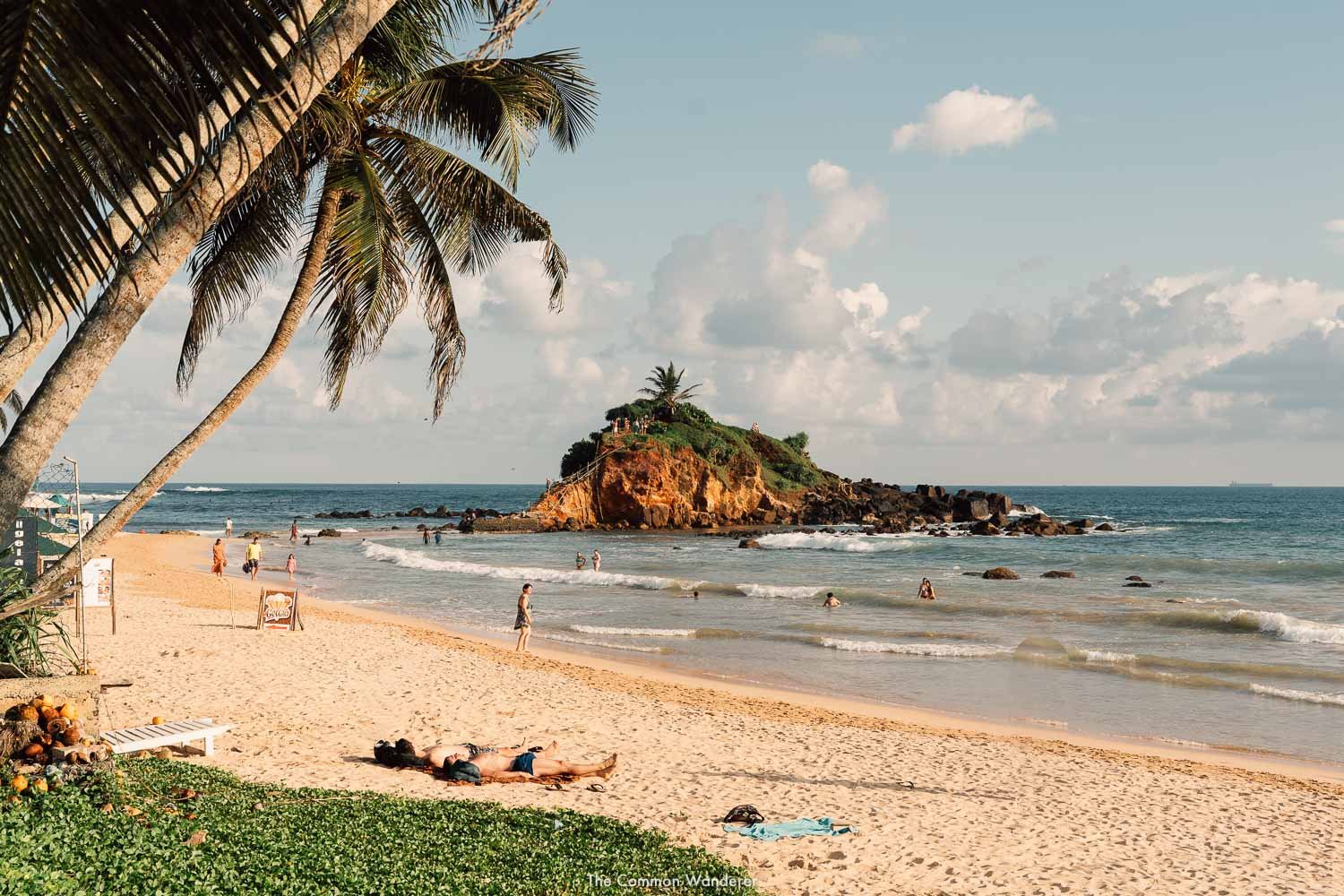 A golden look of the Mirissa beach with people relaxing.