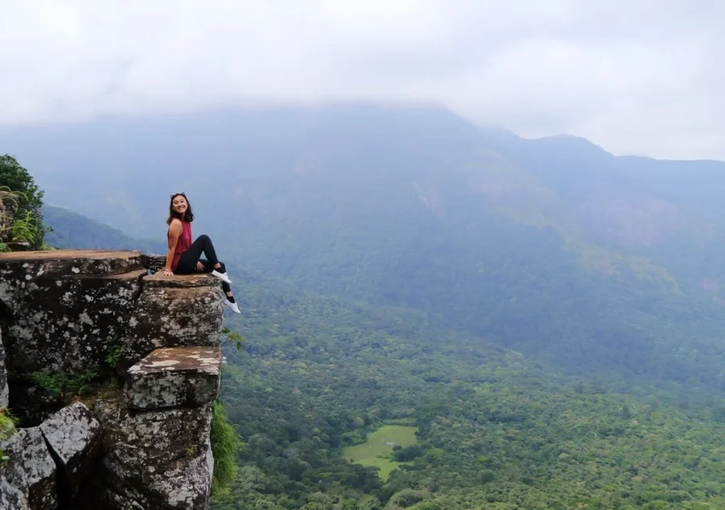 A woman sitting next to the cliff at the Mini World's End in the Knuckles Mountain Range.