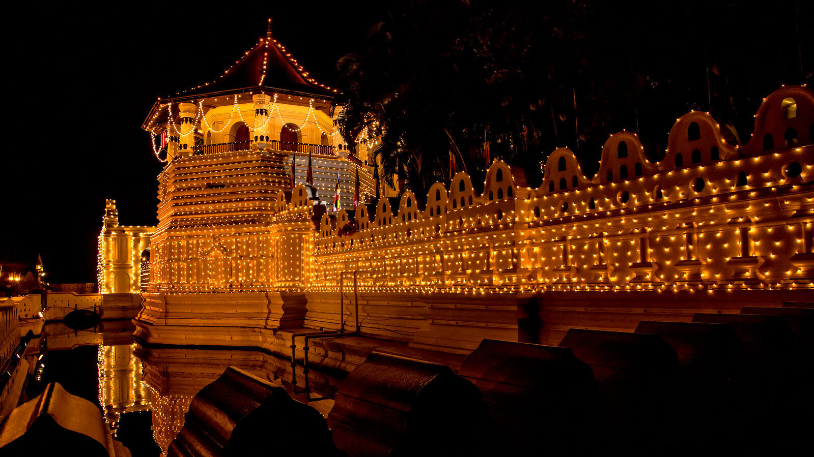 The sacred Temple of the Tooth Relic in Kandy, Sri Lanka, glowing at night.